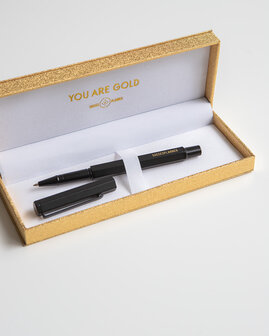 Zwarte pen in gouden doos